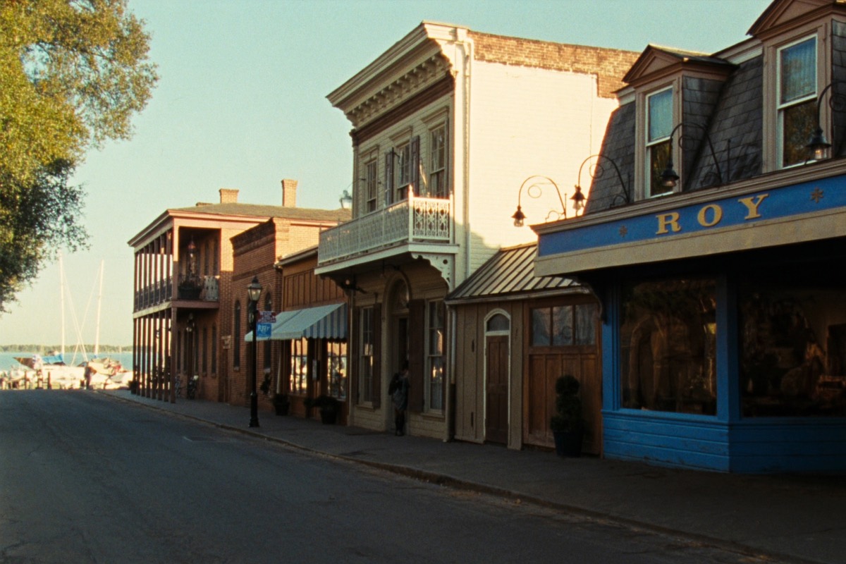 Historic storefronts and a marina along a downtown New Bern, NC waterfront street at golden hour